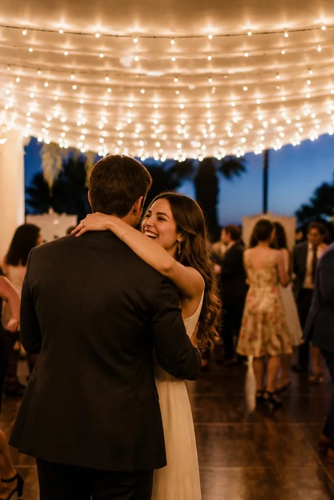 A small dance floor with a soft canopy effect created by warm string lights stretched overhead. The lights hang evenly and create a glow above guests.