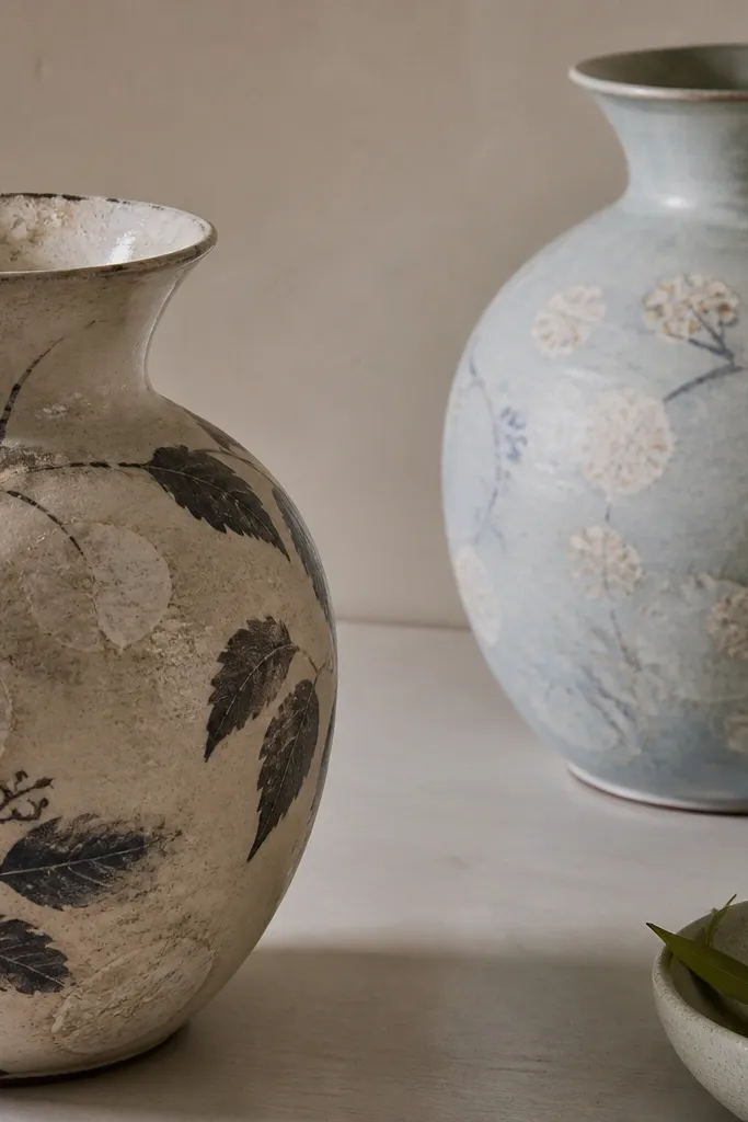 Decorated vases with uneven water spots and cloudy rings on the painted surface; the stains form circles around where water sat.